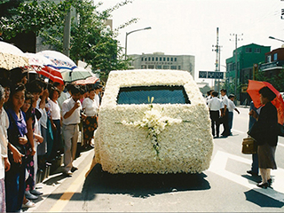 교인들이 한송이 한송이 흰 국화꽃으로 단장한 운구차